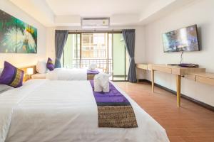 a hotel room with two beds and a desk at Peacock De Pai Hotel in Pai