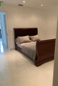 a bed with a wooden frame in a bedroom at room & private bathroom in Boca Raton