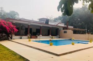 a house with a swimming pool in front of it at Maharaja Kothi Resort, Bandhavgarh in Tāla