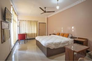 a bedroom with a large bed and a ceiling fan at Maharaja Kothi Resort, Bandhavgarh in Tāla