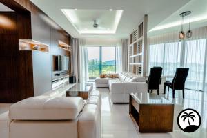 Una sala de estar con sofás blancos y una mesa. en Paradise Suite at the Loft, Imago, en Kota Kinabalu