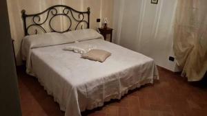 ヴォルテッラにあるAgriturismo Santa Adrianaのベッド(白い毛布、鏡付)