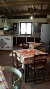 ヴォルテッラにあるAgriturismo Santa Adrianaのキッチン(テーブル、椅子付)、キッチン(冷蔵庫付)