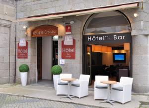 a hotel bar with white chairs and tables in front of it at Hotel Le Croiseur Intra Muros in Saint Malo