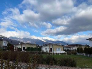 una fila de casas con montañas cubiertas de nieve en el fondo en ViLLA en Peje