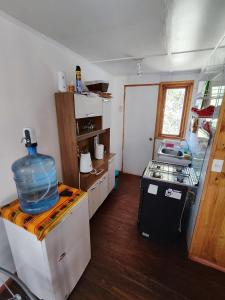 a small kitchen with a fish bowl on top of a refrigerator at CABAÑA SAN PEDRINA in San Pedro de Atacama