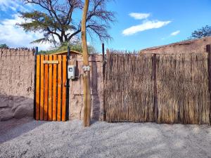 a fence with a wooden gate and a wooden pole at CABAÑA SAN PEDRINA in San Pedro de Atacama