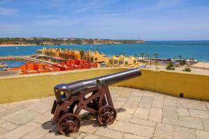 a cannon on a wall with a view of the ocean at Mira Sol - Silhueta Citadina in Portimão
