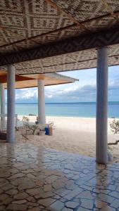 uma vista para uma praia com um pavilhão e para o oceano em Home Stay Ramli em Bira