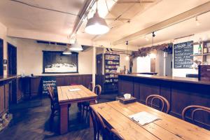 um restaurante com duas mesas de madeira e um bar em Guest House Waya em Sapporo