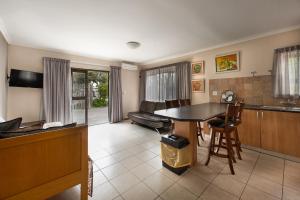 a kitchen and living room with a table and chairs at Guesthouse Fischreiher B&B in Swakopmund