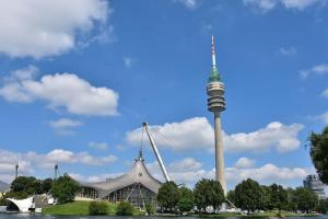 ein großes Gebäude mit einem Turm im Hintergrund in der Unterkunft Liboria I Olympiapark München in München