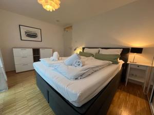 a large bed with white sheets and pillows in a bedroom at Liboria I Olympiapark München in Munich