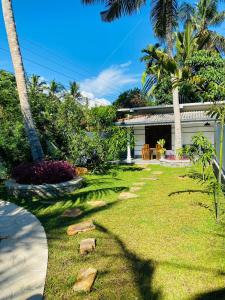 烏納瓦圖納的住宿－Oshi villa，草地上有一所房子和一只猫的院子