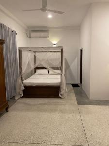 烏納瓦圖納的住宿－Oshi villa，一间卧室配有一张带蚊帐的床