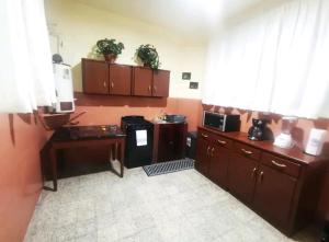 uma cozinha com armários de madeira e um micro-ondas em Departamento vintage em Papantla de Olarte