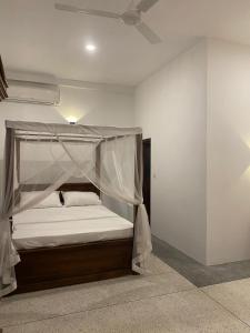 烏納瓦圖納的住宿－Oshi villa，一间卧室配有一张带天蓬的床