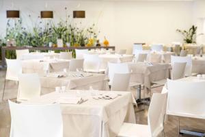 a dining room with white tables and white chairs at Living Place Hotel in Villanova