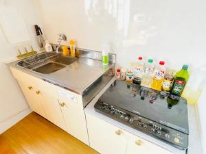 a kitchen with a sink and a stove top oven at AKARIYA Home&Hostel in Karatsu