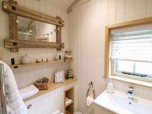 a bathroom with a sink and a mirror at Herbie's Shepherds Hut in Nottingham