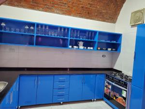 una cocina azul con fregadero y armarios azules en Laila Flat en Al Aqālitah