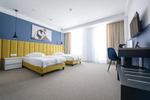 um quarto de hotel com duas camas e uma televisão em Vila Sarisa em Deva