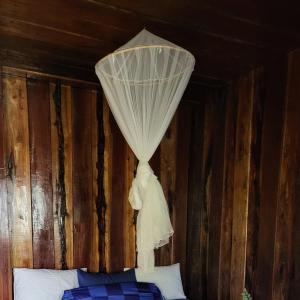 ein Bett mit einem Vorhang an der Decke in der Unterkunft Blondies Koh Rong Villa in Koh Rong