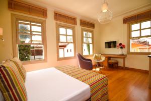 a bedroom with a bed and a desk and windows at Exceptional Studio Flat near Hadrian's Gate in Antalya