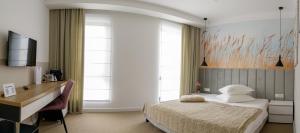 Vila Sarisa في ديفا: غرفة نوم بسرير ومكتب ونوافذ
