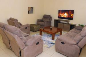 a living room with four chairs and a fireplace at Cool & Calm Home in Homa Bay