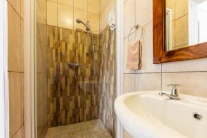 a bathroom with a shower and a sink at Guesthouse Fischreiher B&B in Swakopmund