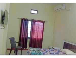 1 dormitorio con 1 cama, 1 silla y 1 ventana en Hotel Shri Ganga, Nalkheda, 