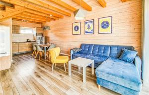 Una sala de estar con un sofá azul y una mesa. en 2 Bedroom Beautiful Home In Sarbinowo, en Sarbinowo