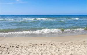 una playa de arena con olas en el océano en 2 Bedroom Beautiful Home In Sarbinowo, en Sarbinowo 8 fotos más
