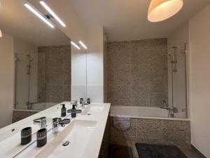 La salle de bains est pourvue d'un lavabo blanc et d'une baignoire. dans l'établissement Le Cartoucherie - 4p - Parking - Tram & Zénith, à Toulouse