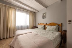 Un dormitorio con una cama grande y una ventana en Guesthouse Fischreiher B&B, en Swakopmund
