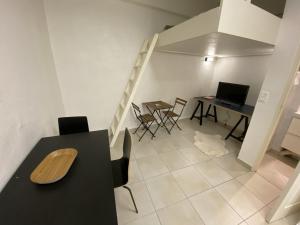 uma sala de estar com uma mesa e cadeiras e uma secretária em La Caverne - Studio au Capitole em Toulouse