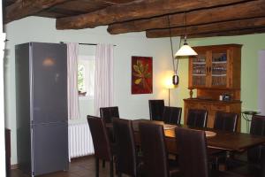 uma sala de jantar com uma mesa e cadeiras e um frigorífico em Cottage - Artland's Home - Landhaus für Familien und Gruppen em Badbergen