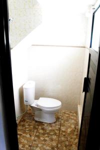 a bathroom with a toilet in a tiled floor at Maguwoharjo Street Homestay Jogja in Seturan