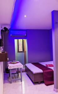 科澤科德的住宿－FAAZ Residency，紫色的客房配有一张床和一张桌子