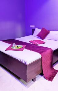 2 camas en una habitación con paredes moradas en FAAZ Residency, en Kozhikode