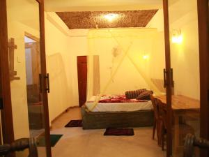 a small room with a bed and a table at Rock Paradise Homestay in Ella