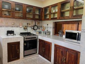 a kitchen with a stove and a microwave at Toiwo Residence Arusha in Arusha