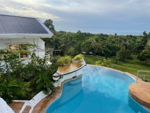 una imagen de una piscina frente a una casa en Vidas Mountain Stay-Bohol, en Baclayon