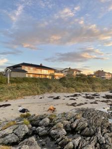 a group of rocks on a beach with buildings in the background at Apartment Utsikten in Andenes