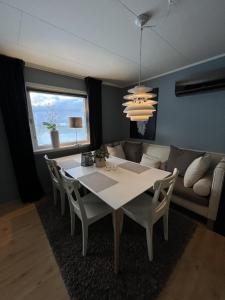 a dining room with a table and chairs and a couch at Apartment Utsikten in Andenes