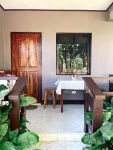 a room with a table and a window with plants at Zara's Casa Rental in Siquijor