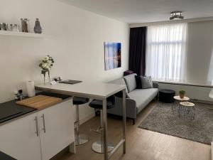 een keuken en een woonkamer met een tafel en een bank bij Rosies Place in Amsterdam