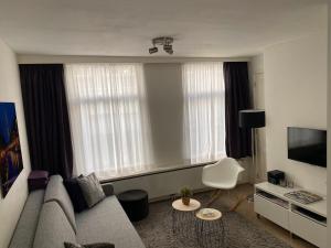 uma sala de estar com um sofá e uma televisão em Rosies Place em Amsterdã