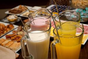 dos vasos de leche y zumo de naranja en una mesa en Hotel Punta del Este en Mar del Plata